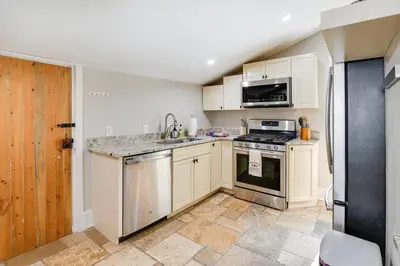 a kitchen with white cabinets and a stove top oven at Bell Street by the Falls in Chagrin Falls
