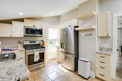 a kitchen with stainless steel appliances and white cabinets at Bell Street by the Falls in Chagrin Falls