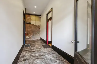 a hallway with doors and a brick wall at Sleek Millersburg Apartment in Downtown! in Millersburg