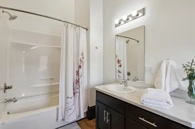 a white bathroom with a sink and a shower at Sleek Millersburg Apartment in Downtown! in Millersburg