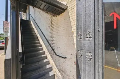 a staircase leading up to a brick building with a door at Sleek Millersburg Apartment in Downtown! in Millersburg