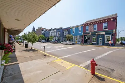 a red fire hydrant on a city street with buildings at Sleek Millersburg Apartment in Downtown! in Millersburg