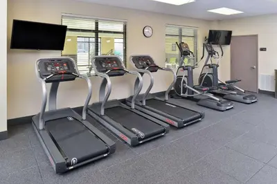 a gym with several cardio machines and a clock at Homewood Suites by Hilton Cincinnati/Mason in Mason