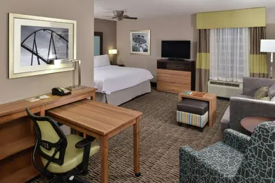 a hotel room with a bedroom with a bed and a desk at Homewood Suites by Hilton Cincinnati/Mason in Mason