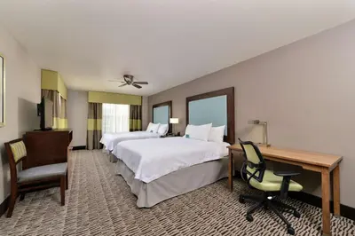 a hotel room with two beds and a desk at Homewood Suites by Hilton Cincinnati/Mason in Mason