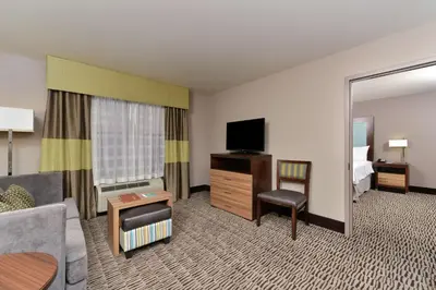 a living room with a couch and a television in a hotel room at Homewood Suites by Hilton Cincinnati/Mason in Mason