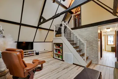 an attic living room with a staircase and a tv at Lakefront St Marys Getaway with Boat Dock and Fire Pit in Southmoor Shores