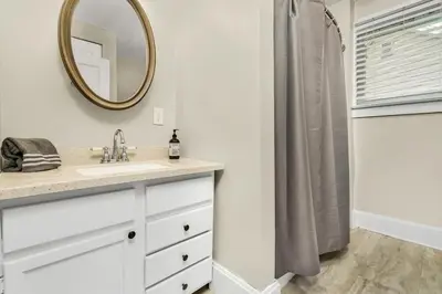 a bathroom with a sink and a mirror at Enchanting Bungalow - 2BR Historic Hidden Gem in Xenia