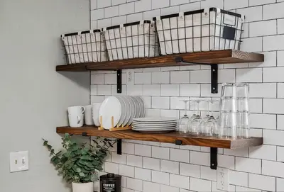 a kitchen with wooden shelves with plates and glasses at Enchanting Bungalow - 2BR Historic Hidden Gem in Xenia