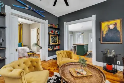 a living room with a table and yellow chairs at Enchanting Bungalow - 2BR Historic Hidden Gem in Xenia