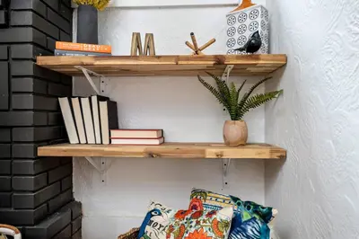 a shelf on a wall with books and a pillow at The Bird Cage in Xenia