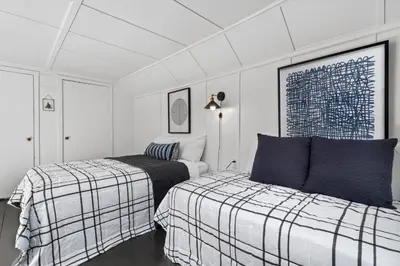 two beds in a room with white walls at The Bird Cage in Xenia