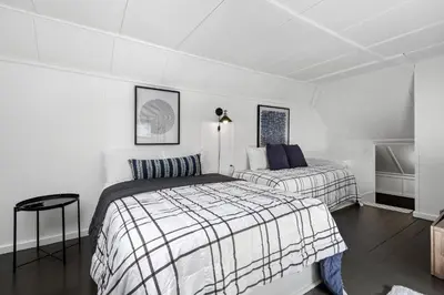 two beds in a room with white walls at The Bird Cage in Xenia