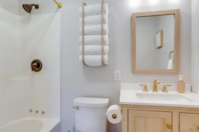 a bathroom with a toilet and a sink and a mirror at Port Clinton Vacation Rental with Boat Dock and Grill! in Port Clinton