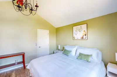 a bedroom with a large white bed and a chandelier at Dog-Friendly Yard! Family Retreat in Fort Wayne in Sunnybrook Acres