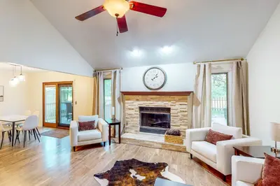 a living room with a fireplace and a clock on the wall at Dog-Friendly Yard! Family Retreat in Fort Wayne in Sunnybrook Acres