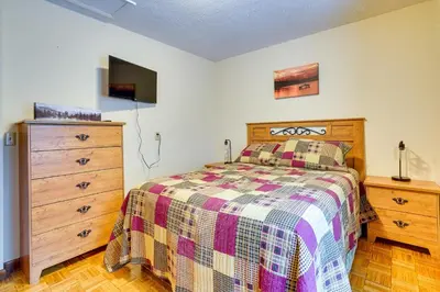 a bedroom with a bed and a wooden dresser at Cabin with Deck about 3 Mi to Apple Valley Lake! in Mount Vernon