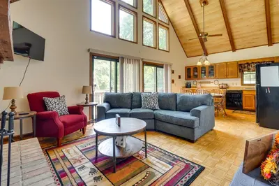 a living room with a couch and a table at Cabin with Deck about 3 Mi to Apple Valley Lake! in Mount Vernon