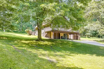 a house with a tree in front of a yard at Cabin with Deck about 3 Mi to Apple Valley Lake! in Mount Vernon