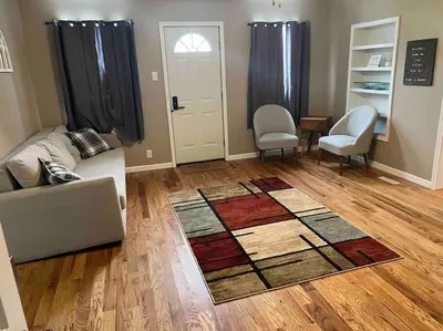 a living room with a couch and chairs and a rug at Entire Home in Cambridge City in Cambridge City