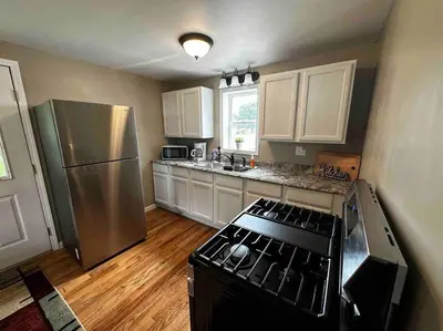 a kitchen with a stove and a stainless steel refrigerator at Entire Home in Cambridge City in Cambridge City