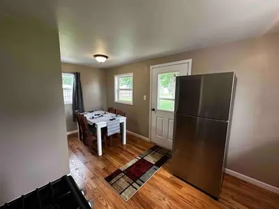 a kitchen with a stainless steel refrigerator and a table at Entire Home in Cambridge City in Cambridge City