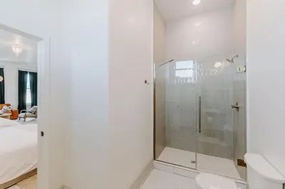 a bathroom with a shower with a toilet and a bed at East Main Lofts in Madison