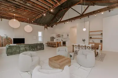 a living room with white furniture and a table at East Main Lofts in Madison