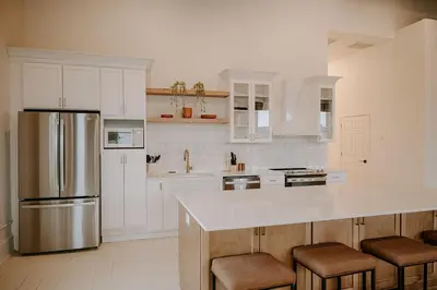 a kitchen with white cabinets and a stainless steel refrigerator at East Main Lofts in Madison