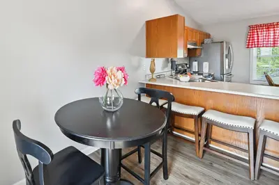 a kitchen with a table with a vase of flowers on it at Corinth Getaway with Deck about 11 Mi to Ark Encounter! in Corinth