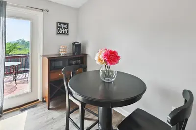 a dining room table with a vase of flowers on it at Corinth Getaway with Deck about 11 Mi to Ark Encounter! in Corinth