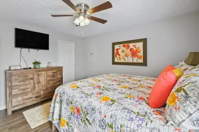 a bedroom with a bed and a ceiling fan at Corinth Getaway with Deck about 11 Mi to Ark Encounter! in Corinth