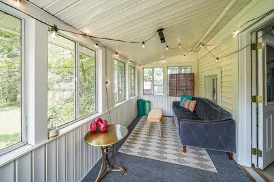 a screened in porch with a couch and a table at Small town vibes in Garrettsville. in Garrettsville