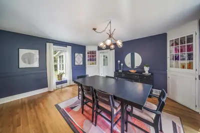 a dining room with a black table and blue walls at Small town vibes in Garrettsville. in Garrettsville