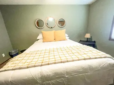 a bedroom with a large bed with two mirrors on the wall at Rye Beach Family Cottage in Huron