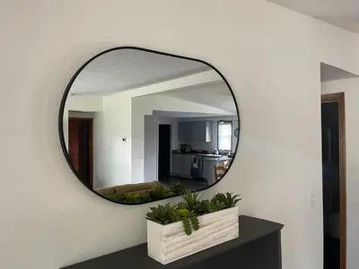 a mirror on a wall in a living room at Rye Beach Family Cottage in Huron