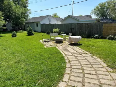 a backyard with two chairs and a brick path at Rye Beach Family Cottage in Huron