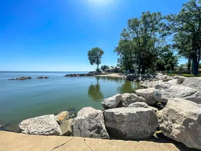 a body of water with rocks in the water at Rye Beach Family Cottage in Huron