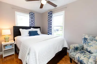 a bedroom with a bed and a chair at Explorers Cottage at Rye Beach in Huron