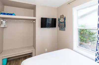 a bedroom with a bed and a tv and a window at Explorers Cottage at Rye Beach in Huron