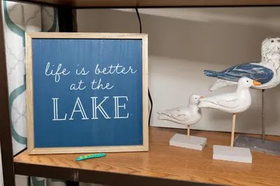 a sign that says life is better at the lake on a shelf at Explorers Cottage at Rye Beach in Huron