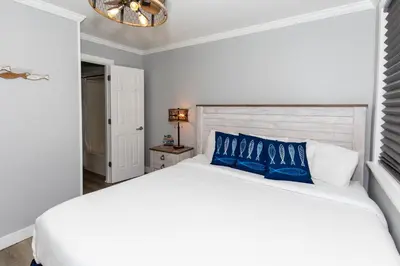 a bedroom with a white bed with blue pillows at Downtown Waterfront Escape in Sandusky