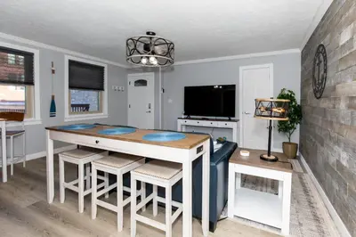 a dining room with a table and chairs and a tv at Downtown Waterfront Escape in Sandusky