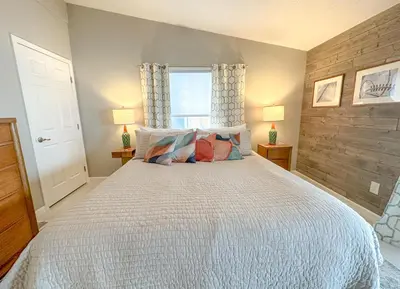 a bedroom with a white bed with two lamps and a window at Lakefront 5 Bedroom Vacation Home - Sleeps 12! in Vermilion