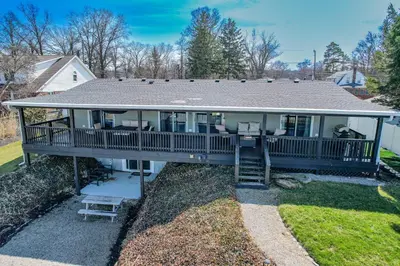 a home with a large deck with furniture on it at Lakefront 5 Bedroom Vacation Home - Sleeps 12! in Vermilion