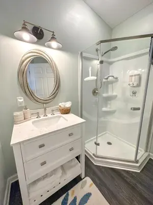 a bathroom with a shower and a sink and a mirror at Lakefront 5 Bedroom Vacation Home - Sleeps 12! in Vermilion
