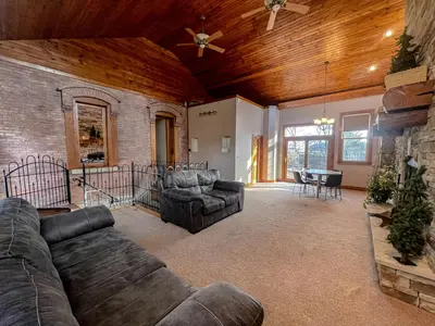 a living room with two couches and a dining room at Charming School House with Large Pool in Huron