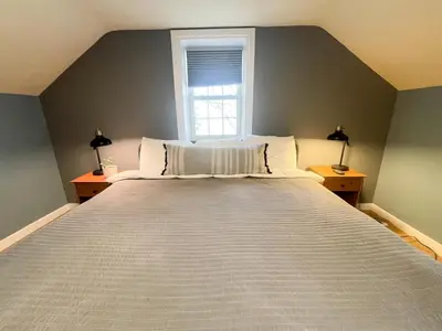 a large bed in a room with a window at Charming School House with Large Pool in Huron