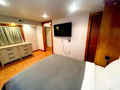 a bedroom with a bed and a flat screen tv at Charming School House with Large Pool in Huron