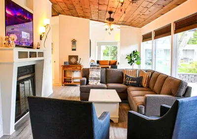 a living room with a couch and a fireplace at Newly Renovated! Old Homestead Beach Home in Huron